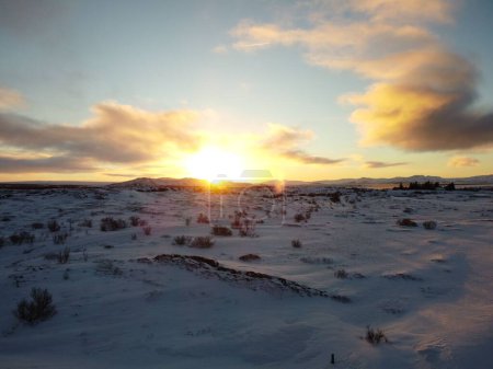 Foto de Una vista panorámica del campo cubierto de nieve al atardecer - Imagen libre de derechos