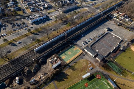 Foto de Una vista aérea sobre un barrio comercial en Long Island, NY en un día soleado con una línea de tren - Imagen libre de derechos