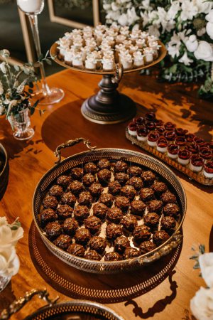 Téléchargez les photos : Savoureux biscuits et bouquets de cerises au chocolat noir sur une table en bois lors d'une fête de mariage, plan vertical - en image libre de droit