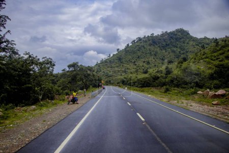 Foto de Un paisaje de un camino pavimentado entre los bosques en Nathadwara, India - Imagen libre de derechos