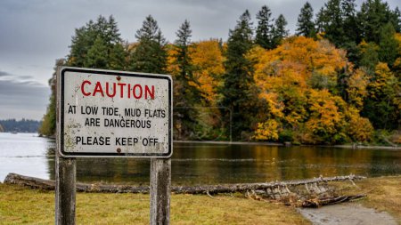 Téléchargez les photos : Un panneau d'avertissement au bord du lac par un jour sombre - en image libre de droit
