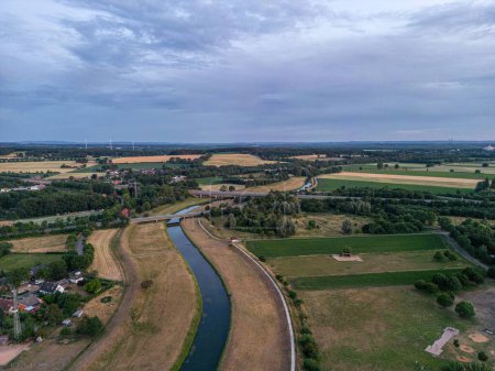Photo for An aerial shot of the narrow river between the field in small village - Royalty Free Image
