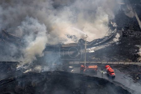 Téléchargez les photos : Un tir aérien de pompiers éteignant un incendie dans des réservoirs de carburant à la base de supertanker à Matanzas, Cuba - en image libre de droit