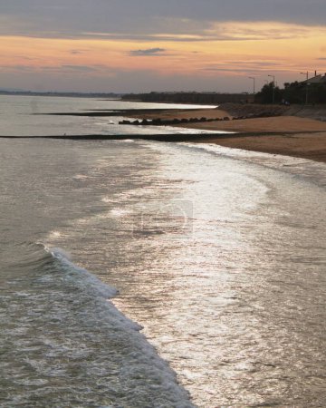 Foto de Un plano vertical de una idílica playa de arena al atardecer - Imagen libre de derechos