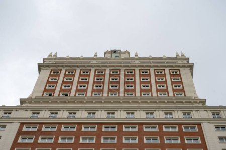 Téléchargez les photos : Une vue en angle bas du grand bâtiment Espagne hypnotisant, Edificio Espana avec une belle architecture sous le ciel nuageux - en image libre de droit