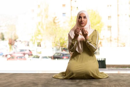Foto de Un retrato de una hermosa mujer musulmana humilde rezando en paz en una mezquita - Imagen libre de derechos