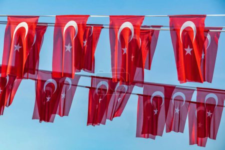 Foto de Una luna y una bandera turca roja estrellada con un fondo azul del cielo - Imagen libre de derechos