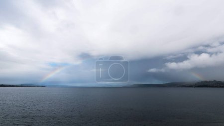 Téléchargez les photos : Un tir de drone d'un arc-en-ciel sur un lac en Nouvelle-Zélande sous le ciel nuageux - en image libre de droit