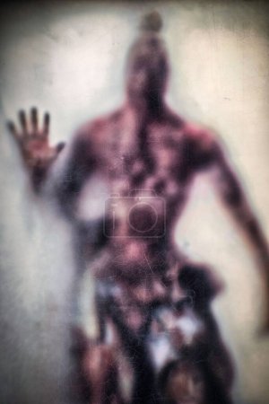 Téléchargez les photos : Un plan vertical de la personne effrayante reflétée dans le miroir brouillé par la vapeur - en image libre de droit