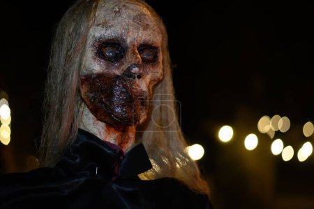 Téléchargez les photos : Une sorcière avec un balai et un visage de monstre lors d'une sombre nuit d'horreur d'Halloween, fond clair bokeh - en image libre de droit