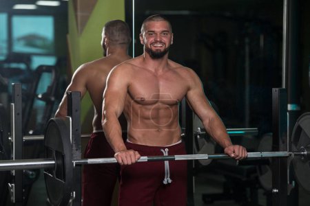 Foto de Un caucásico de buen aspecto atractivo Masculino ejercicio de entrenamiento con pesas en el gimnasio - Imagen libre de derechos