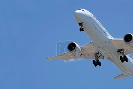 Téléchargez les photos : Un avion approchant avec son train d'atterrissage sorti contre un ciel bleu près de l'aéroport de Los Angeles - en image libre de droit