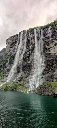 Téléchargez les photos : Un plan vertical de la cascade des Sept Sœurs sous un ciel nuageux à Stranda, More og Romsdal, Norvège - en image libre de droit