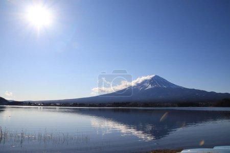 Téléchargez les photos : Une vue du paysage de la montagne enneigée reflétée dans l'eau contre un ciel bleu - en image libre de droit