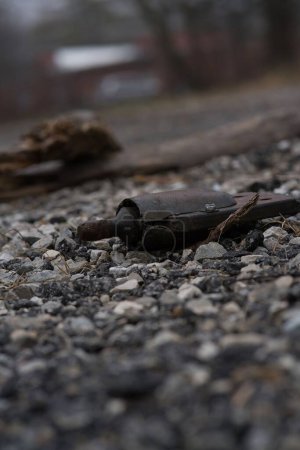 Photo for A vertical shot of random metal rusty scrap on rocky surface outdoors on the blurred background - Royalty Free Image