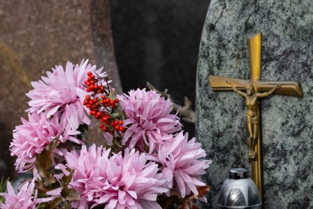 Photo for A close-up shot of flowers on gravestones in cemetery - Royalty Free Image