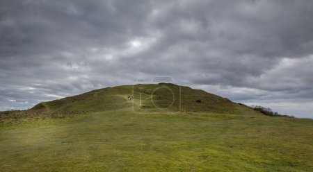 Téléchargez les photos : Une personne descendant la colline avec un ciel nuageux à l'horizon - en image libre de droit