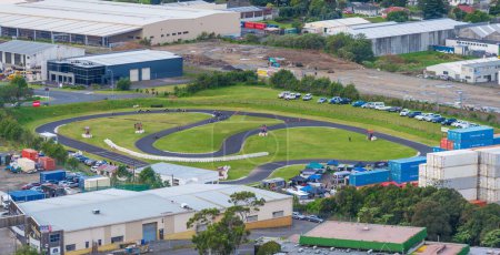 Téléchargez les photos : Vue aérienne d'un champ de karting à Auckland, en Nouvelle-Zélande, dans une zone industrielle, avec des voitures garées dans un parking - en image libre de droit