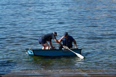 Téléchargez les photos : Deux hommes, ramant dans un petit bateau, en eau peu profonde, à Madère, au Portugal, par une journée ensoleillée - en image libre de droit