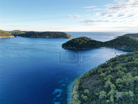 Photo for A scenic bird's eye view of boats sailing in the tranquil sea in an evergreen island - Royalty Free Image