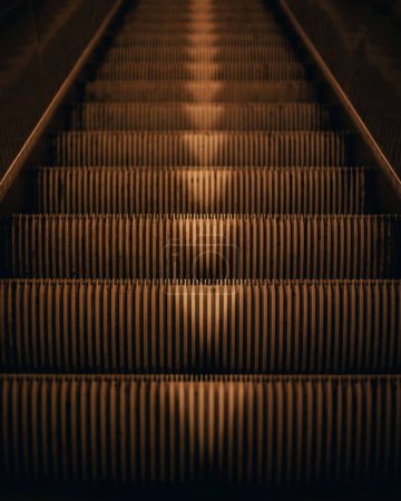 Téléchargez les photos : Un plan vertical d'escaliers mécaniques avec des flèches pointant vers le bas - en image libre de droit