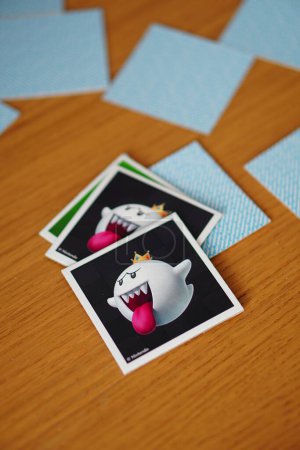Téléchargez les photos : Un plan vertical de cartes d'un jeu de mémoire Ravensburger Super Mario montrant un fantôme sur une table en bois - en image libre de droit