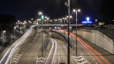 Foto de Una amplia gama de autopistas con diferentes salidas nocturnas, iluminadas con luces - Imagen libre de derechos