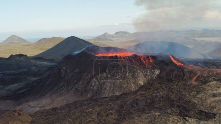 Foto de Un paisaje de erupción del volcán Mauna Loa en Hawai con humo y cielo azul - Imagen libre de derechos