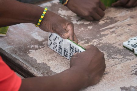 Foto de Un primer plano de manos negras latinas jugando dominó en el barrio de La Marina Matanzas, Cuba - Imagen libre de derechos