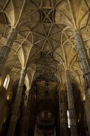 Foto de Un primer plano vertical de una vista interior del Monasterio de Jerónimos con un techo arqueado - Imagen libre de derechos