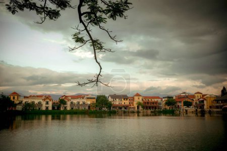 Téléchargez les photos : Une belle vue sur les bâtiments au bord d'un lac sous un ciel nuageux. - en image libre de droit
