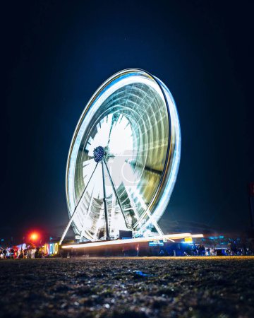 Téléchargez les photos : Un plan vertical d'une grande roue en rotation éclairée avec une longue exposition - en image libre de droit