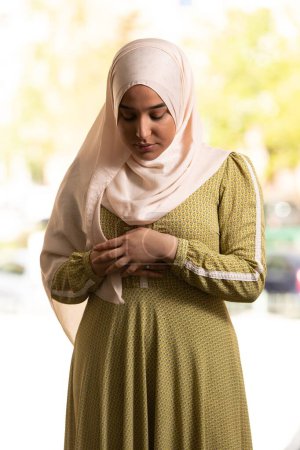 Téléchargez les photos : Une belle femme musulmane habillée en hijab dans la mosquée et priant - en image libre de droit