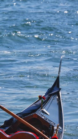 Téléchargez les photos : Un plan vertical de l'avant d'un bateau de gondole avec son fer à proue, sur les eaux brillantes - en image libre de droit