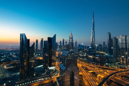 Photo for The skyline of the Burj Khalifa tower and the illuminated highways at the twilight in Dubai UAE - Royalty Free Image