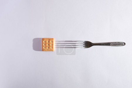Photo for A small biscuit and a fork isolated on a white background - Royalty Free Image