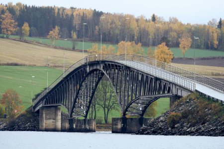 Foto de Un hermoso puente sobre los Nes y Helga, ya Island en el lago Mja, un día nublado en otoño. - Imagen libre de derechos