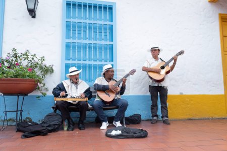 Téléchargez les photos : Medellin, Colombie - 30 juillet 2022 : Un trio de musiciens traditionnels colombiens âgés jouant de la musique dans la rue. L'un joue du xylophone et les deux autres de la guitare. - en image libre de droit
