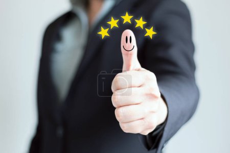 Businessman in suit without tie with thumb up. Five star rating. Smiley face on a thumb. Concept of quality evaluation and business success.