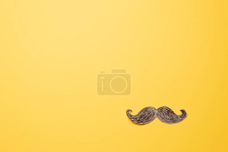 Téléchargez les photos : Moustache en papier isolée avec des pointes bouclées au coin inférieur sur fond jaune - en image libre de droit