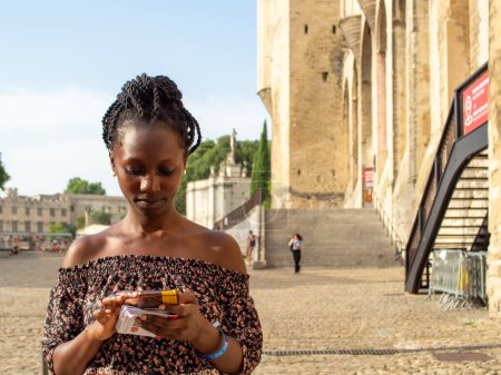 Photo for Young beautiful woman typing while standing in an french historical place Avignon - Royalty Free Image