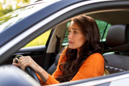 Jeune femme européenne effrayée conduisant une voiture et ayant survécu à un accident, dame regardant un accident ou un animal sur la route, vue de la fenêtre ouverte