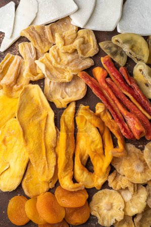 Photo for Assorted exotic dried fruits. Dried mango, papaya, pineapple, jackfruit, date, apricot, melon, pineapple, passion fruit, ginger. Top view - Royalty Free Image