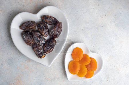 Téléchargez les photos : Abricots secs et dattes fruits avec chapelet en bois sur table en bois. Vue du dessus. - en image libre de droit