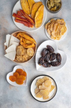 Photo for Assorted exotic dried fruits on plates on a white background. Top view - Royalty Free Image