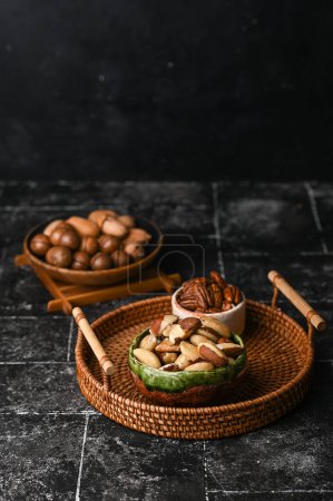 Photo for Various Nuts in wooden bowl on dark background. Free space for your text. - Royalty Free Image