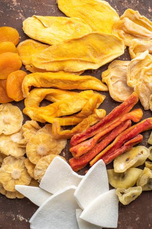 Photo for Assorted exotic dried fruits. Dried mango, papaya, pineapple, jackfruit, date, apricot, melon, pineapple, passion fruit, ginger. Top view - Royalty Free Image