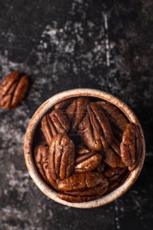 Photo for Pecan nuts on a rustic wooden table and pecan nuts in bowl. Top preview. Free space for your text. - Royalty Free Image