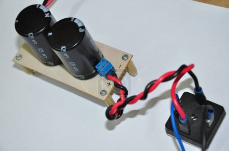 Téléchargez les photos : Condensateur électrolytique et pont de diode qui font partie du circuit de convertisseur de tension, sont connectés par des fils bleus et rouges. le circuit convertit la tension CA en courant continu - en image libre de droit