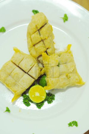 Téléchargez les photos : Photo rapprochée de trois morceaux de l'une des spécialités de Bandung - Indonésie, "Batagor" (gâteau de poisson) servi sur une assiette blanche. - en image libre de droit